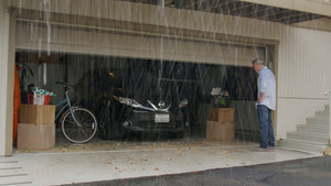Homme debout à l'extérieur d'un garage sous la pluie